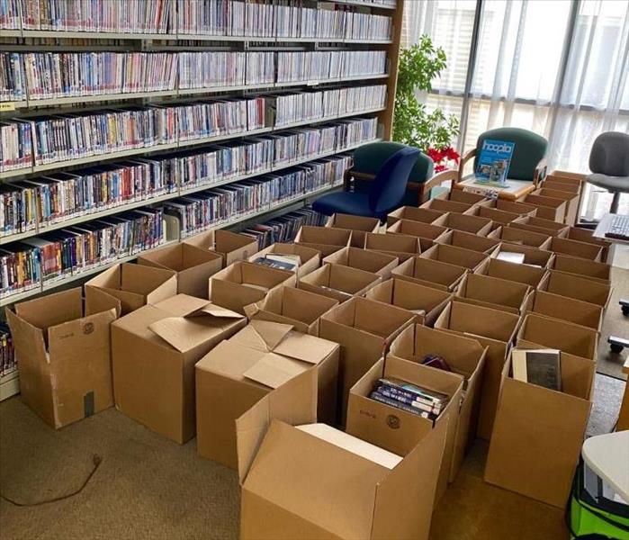 Hundreds of books being packed away into boxes in a library